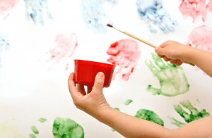 Childrens hand  painting brush watercolors on a easel