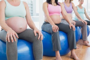 Pregnant women sitting on exercise balls in a fitness studio