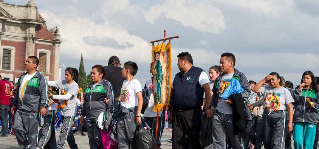 Celebra-dia-de-la-virgen-de-guadalupe-en-los-angeles-gente-caminando-con-foto-de-la-virgen-en-frente-de-basilica-en-ciudad-mexico