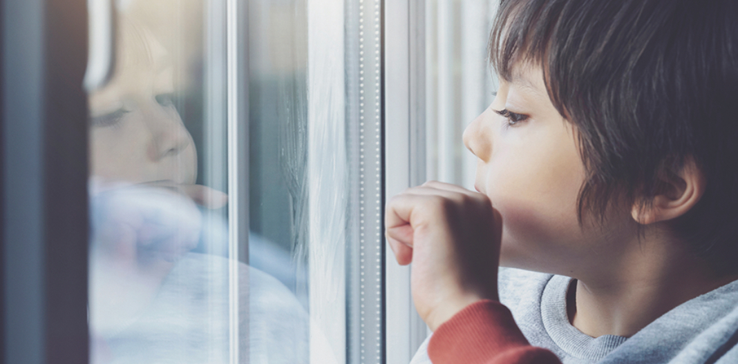 Niño viendo su reflejo en una ventana