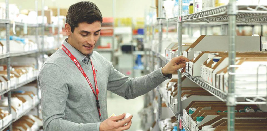 hombre revisando un frasco de medicinas en una farmacia
