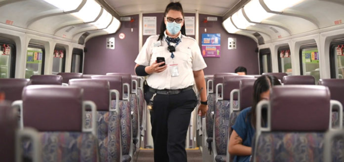 Mujer con cubrebocas inspeccionando el interior de un tren
