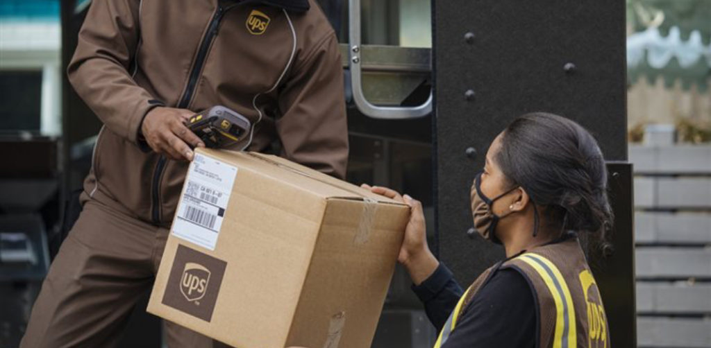 Trabajadores de UPS manipulando un paquete