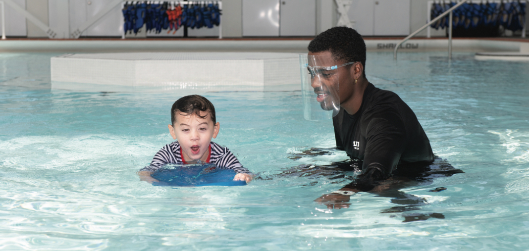 Instructor enseñando a un niño a nadar