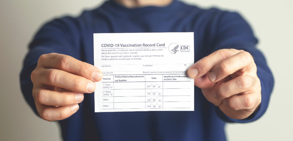 Persona mostrando su tarjeta de vacunación contra el COVID