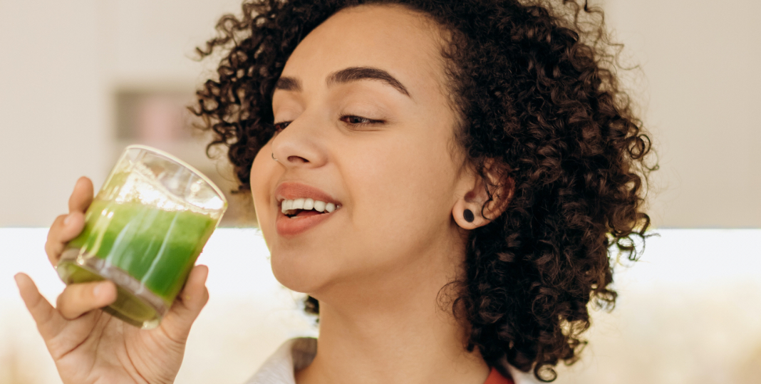 Mujer tomando un jugo verde