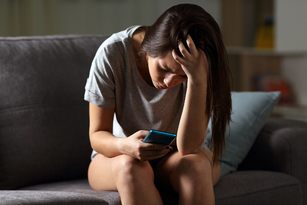 Adolescente deprimida enviando un mensaje de texto