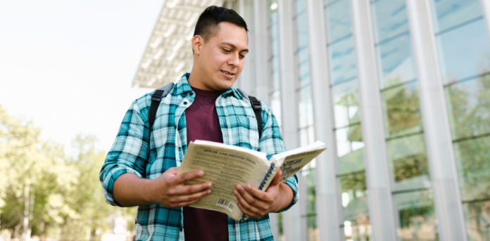 Estudiante hispano con un libro en las manos Estudiante hispano con un libro en las manos
