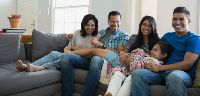 Familia latina sentada en un sofá