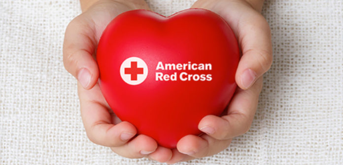 Manos con un corazón de la Cruz Roja