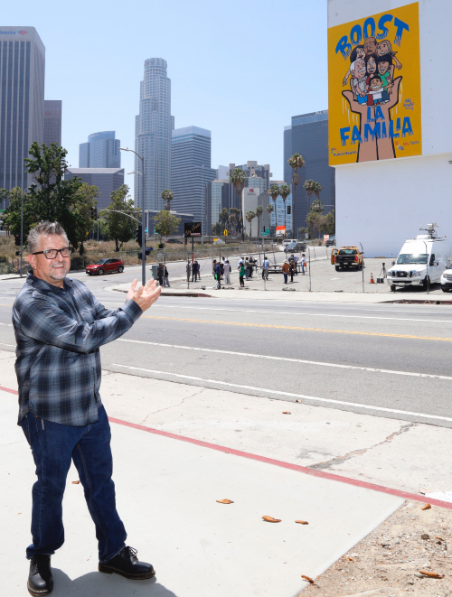Lalo Alcaraz señala su mural en un edificio de Los Ángeles