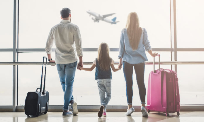 Familia con maletas viendo un avión