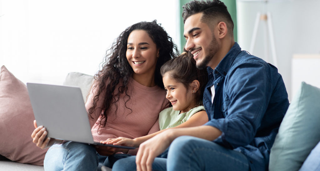 Familia latina usando internet en una laptop