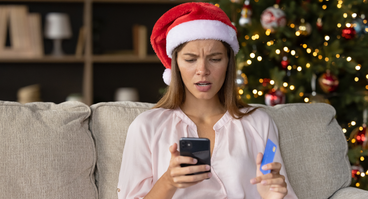 Mujer con gorro de Navidad revisando su teléfono