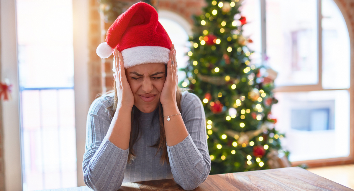 Mujer con gorro de Navidad y estresada