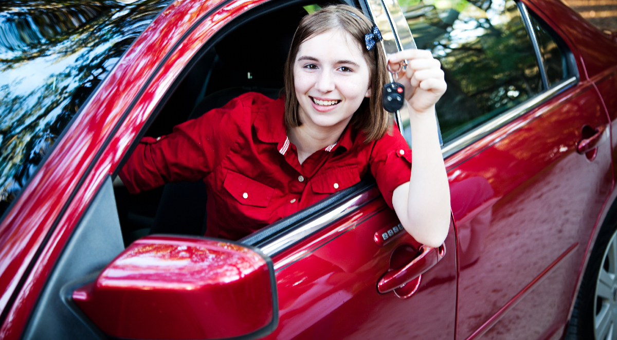 Adolescente adentro de un auto rojo