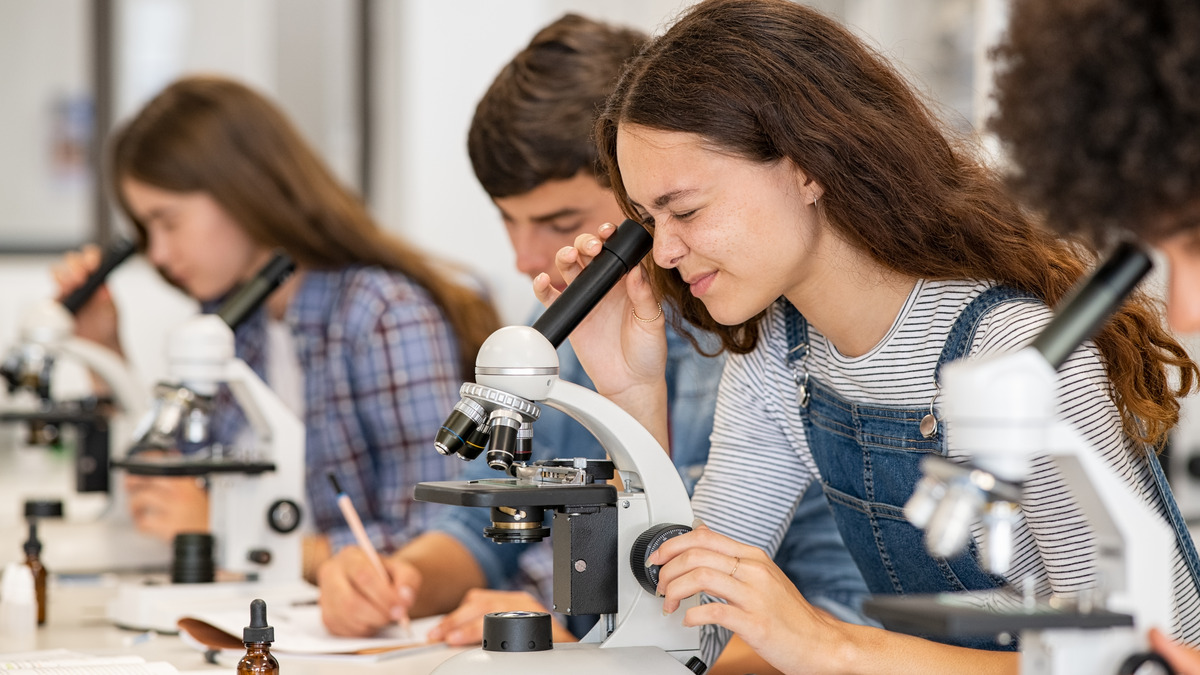 Jóvenes estudiantes con microscopios