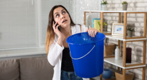 Mujer con una cubeta atrapando agua