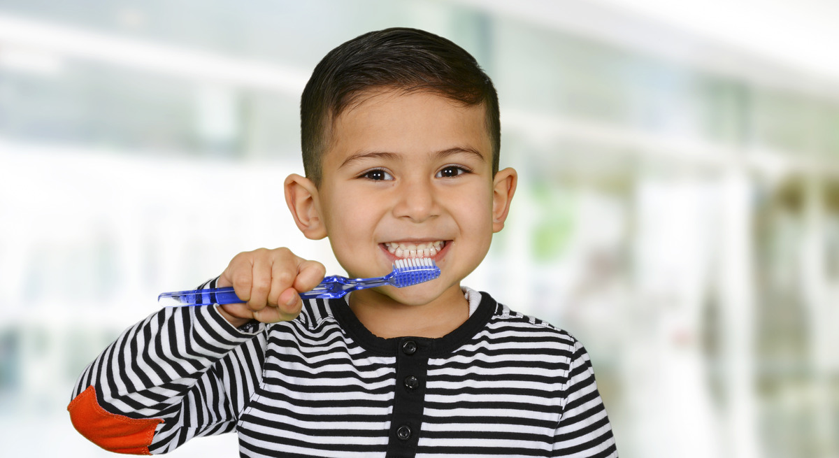 Niño latino cepillándose los dientes