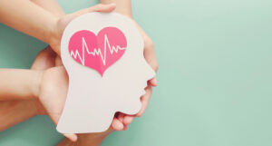 Manos con una cartulina en forma de cabeza