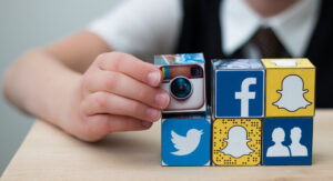 Niña acomodando cubos con logos de redes sociales