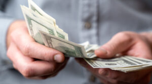 Persona contando dinero con las manos