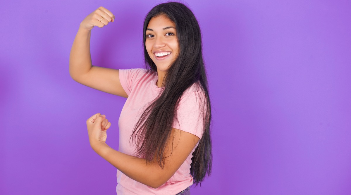 Chica latina con los brazos en señal de fuerza
