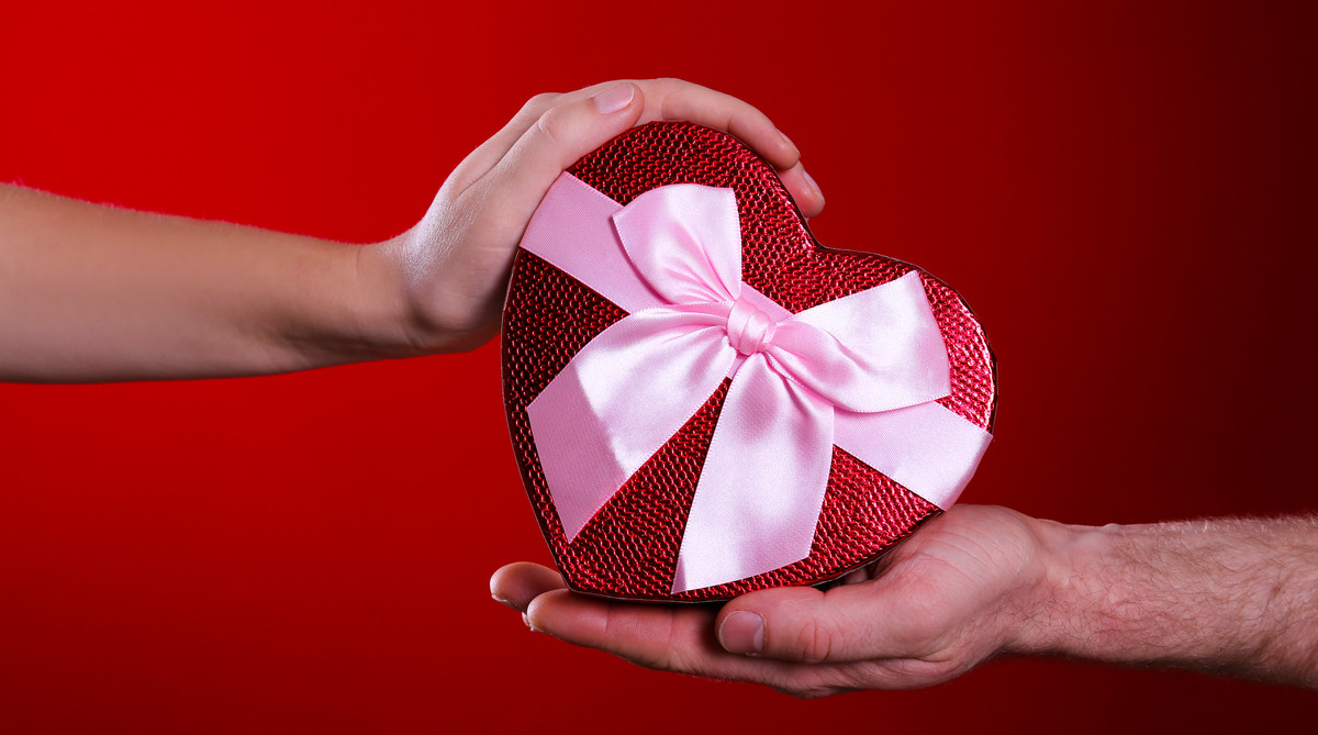 Dos manos sujetan un regalo de San Valentín
