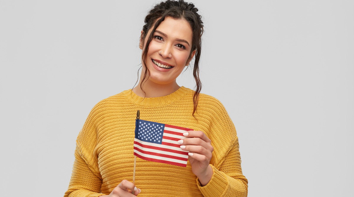 Mujer latina con una banderita de Estados Unidos
