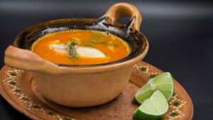 Caldo Michi en una cazuelita de barro y dos rebanadas de limón