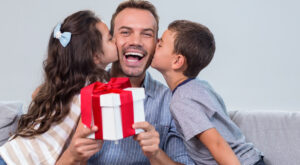 Dos niños besan a su papá