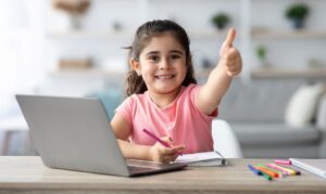 Niña latina haciendo la tarea con su laptop
